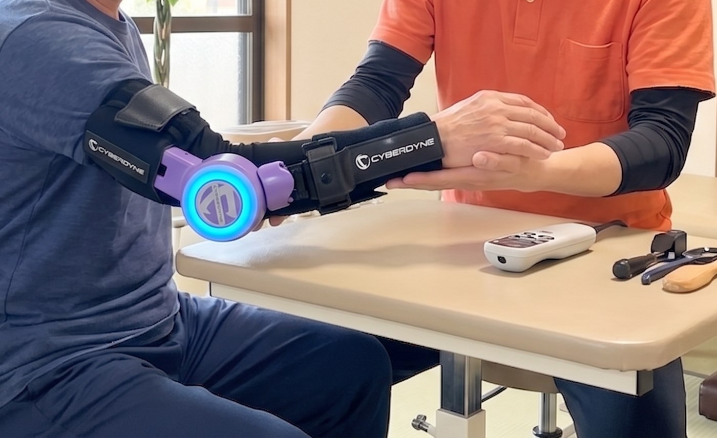 ロボットスーツHALを腕に装着してリハビリを行う様子